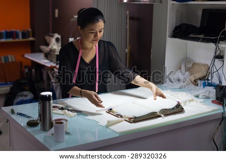 Asian woman tailor fashion clothes dress designer working with fabric on table