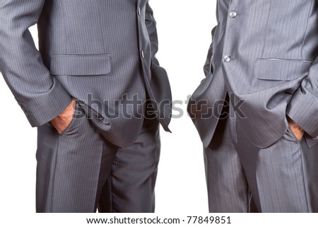 Professionally well dressed two caucasian businessmen in elegant suits, top managers standing holding hands in pockets isolated on white background. Concept corporate.