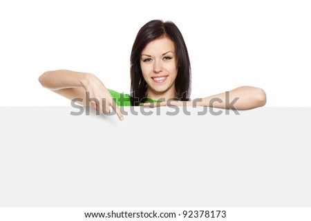young happy smile woman standing hold pointing her finger at a blank board, attractive girl wear green shirt, isolated over white background, studio shoot