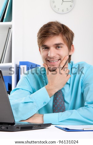 businessman happy smile sitting at the desk in office, handsome young business man wear blue shirt.