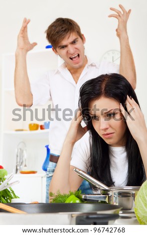 portrait of young couple conflict in their kitchen, relationship problem, negative emotion, aggressive man scream on woman, she is crying with tears on eyes