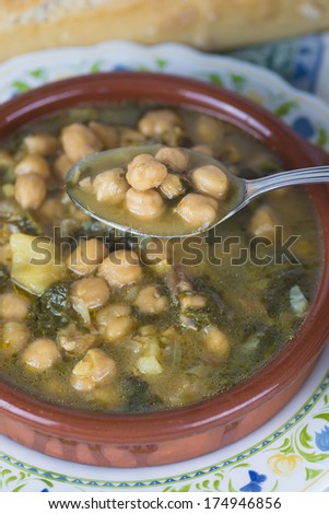 Stew of chickpeas and spinach with cod on a  table with a tablecloth