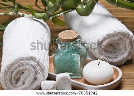 Spa background with bamboo plants, candles and bath salts in green.