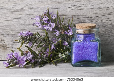 Rosemary with bath salts on a wooden surface.