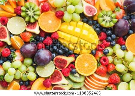 Assortment of healthy raw fruits and berries platter background, strawberries raspberries oranges plums apples kiwis grapes blueberries, mango, top view, selective focus ストックフォト © 