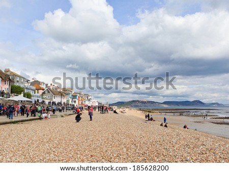 LYME REGIS, ENGLAND - APRIL 08: People on Lyme Regis Beach, Dorset, England, April 08, 2012. The town is famous for the fossils found in the cliffs; Lyme Regis beach is the part of the Jurassic Coast.