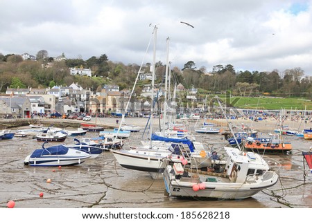 LYME REGIS, ENGLAND - APRIL 08: Boats in low tide, Lyme Regis harbour, Jurassic Coast, Dorset, England, April 08, 2012. The town is famous for the fossils found in the cliffs and beaches.