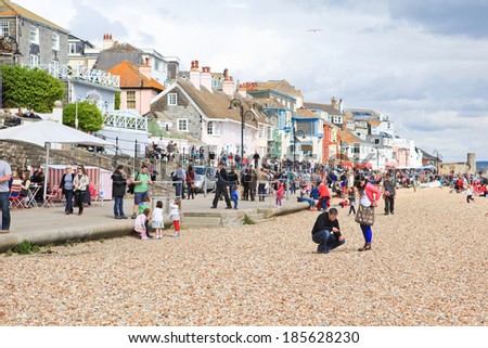 LYME REGIS, ENGLAND - APRIL 08: People on Lyme Regis Beach, Dorset, England, April 08, 2012. The town is famous for the fossils found in the cliffs; Lyme Regis beach is the part of the Jurassic Coast.