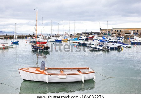 LYME REGIS, ENGLAND - APRIL 08: Boats in high tide, Lyme Regis harbour, Jurassic Coast, Dorset, England, April 08, 2012. The town is famous for the fossils found in the cliffs and beaches.
