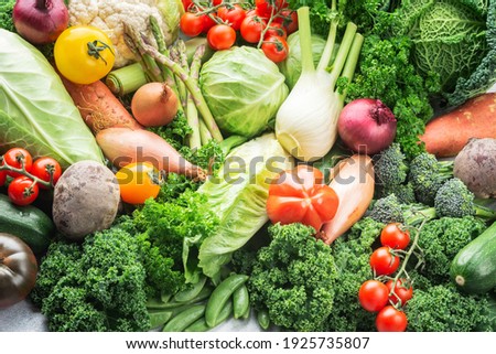 Abundance of different vegetables broccoli cauliflower cabbage kale pak choy onions tomatoes. Healthy local produce on white wooden table, top view, selective focus