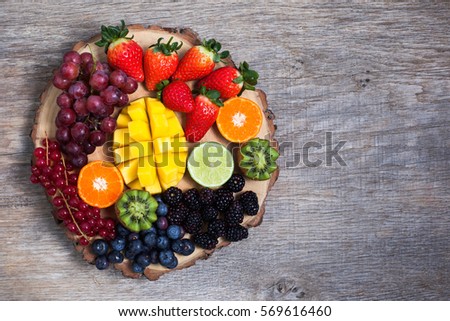 Raw fruit and berries platter, mango, kiwis, strawberries, blueberries, blackberries, red currants, grapes, top view, copyspace for text ストックフォト © 