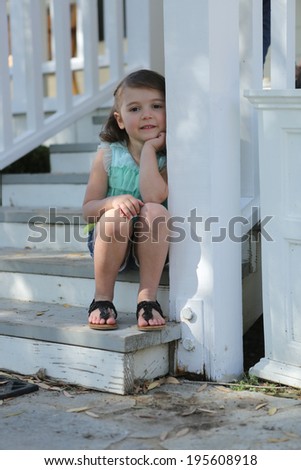 Small Child Sitting on the Porch Outside