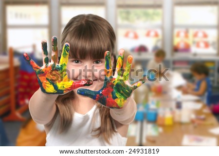 Happy Girl Painting With Her Hands in Kindergarten Class