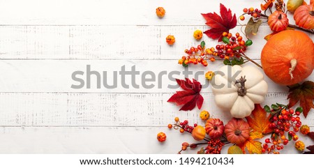 Festive autumn decor from pumpkins, berries and leaves on a white  wooden background. Concept of Thanksgiving day or Halloween. Flat lay autumn composition with copy space. Foto d'archivio © 