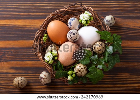 eggs in a nest with flowers,feathers on a wooden table
