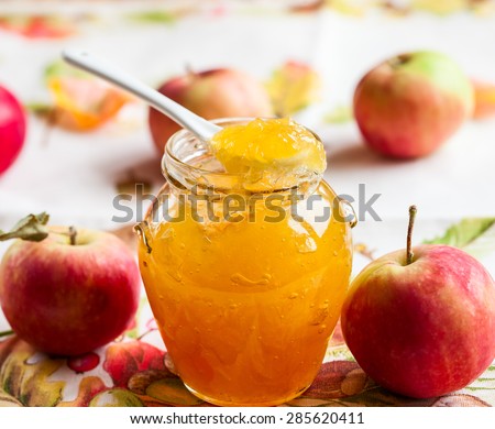 Apple jam in a jar and fresh red apples