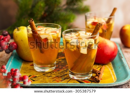 Fall and winter  drink with apples,pears and cinnamon in glasses on the vintage tray