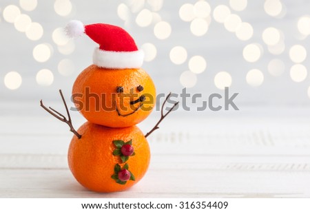 Happy snowman made out of tangerines,clove and winter berries