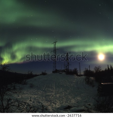 120 format slide film scan Aurora borealis in the night sky accompanied with the Moon above scientific antennas