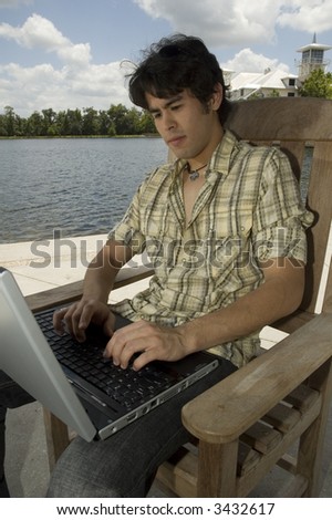 Handsome young man surfing the internet in an outdoor setting