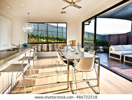 Modern Kitchen And Dining Area On The Wooden Floor With Sunlight From Outside Into Modern Kitchen And Dining Area On The Wooden Floor With Sunlight From Outside Into
