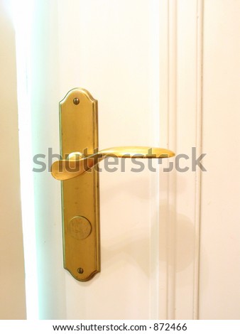 Golden door handle with bright hazy light streaming from door crack
