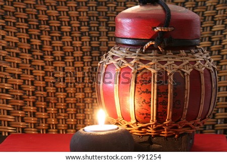 Old burmese jar with a lit candle. Taken at ISO 100 (lowest setting) to minimize noise.