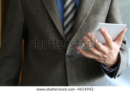 Smartly dressed business man holding a writing pad.