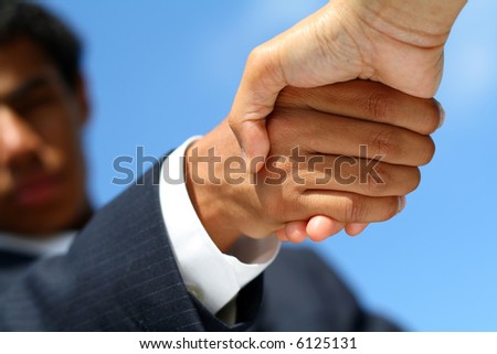 Business man dressed in suit shaking hands with another person. Concept: Deal done or agreement made.