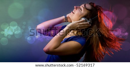 Young girl having fun at a disco or nightclub with retro headphones listening to music