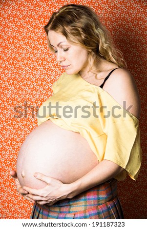 Pregnant expectant mother looks at her big belly