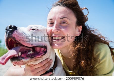 Girl hugging dog breed Staffordshire Terrier