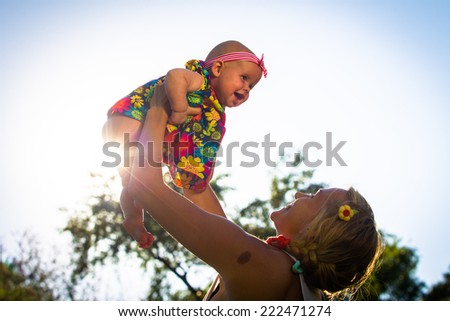 Mom throws up into the sky on the background of your child of the setting sun