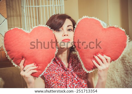 A young girl holding two big hearts