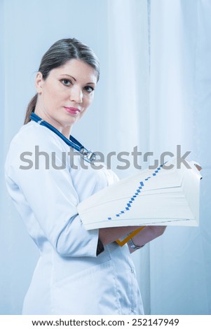 Doctor with medical reference book in the hands of