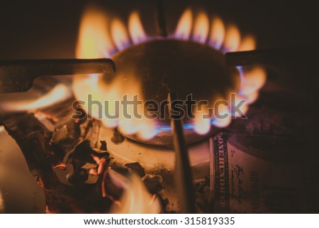 Gas stove. Dollars on a gas stove. Processed with toning effect