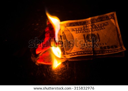 One hundred dollar bill on fire