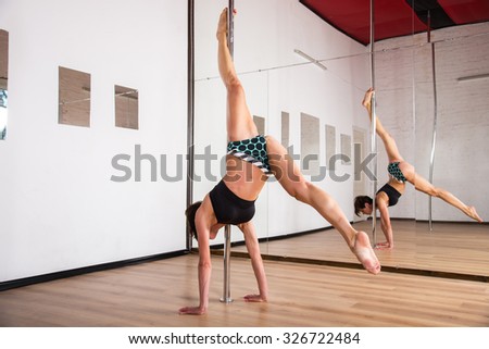 Pole Dance. Gymnast coached exercises on pole