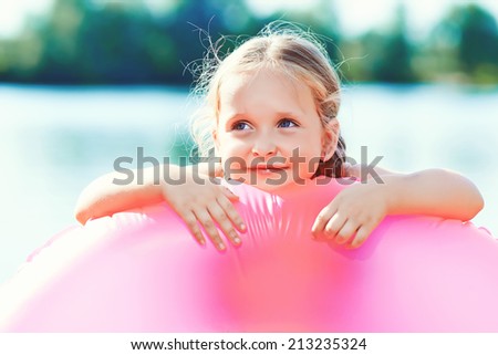 happy girl and swim ring at the beach. toned image