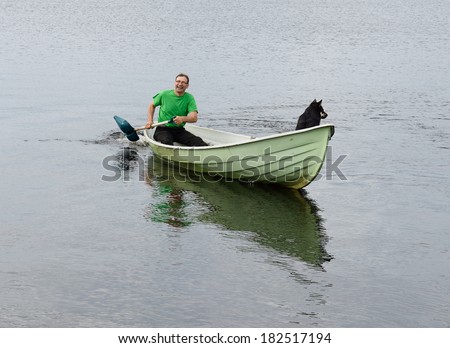 Man floating on boat with shovel instead of paddle and laughs.