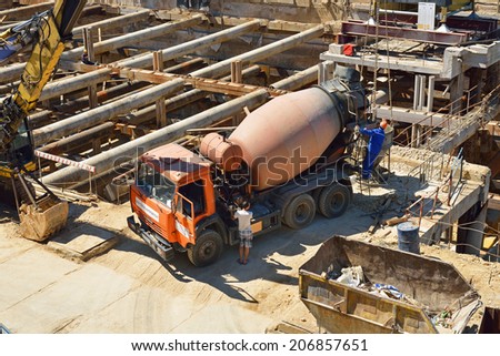MOSCOW, RUSSIA - JULY 13, 2014:Cement mixer truck works at building site under construction at home in downtown. In Moscow for first half of year 2014 more than 1,5 million sq.m of housing are entered