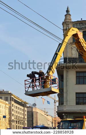 MOSCOW, RUSSIA - NOVEMBER 4, 2014:Videographer produces video report from height of crane of National Unity Day in center near hotel Metropol
