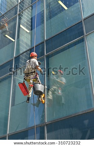 MOSCOW, RUSSIA - MAY 25, 2015: Group of workers cleaning windows service of modern office building in Moscow International Business Center