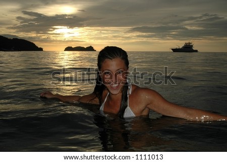 sexy female model wades in water at exotic tropical beach