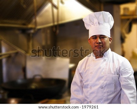 chef standing with blurred kitchen background