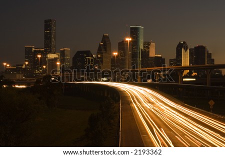 view of downtown houston framed cars light on highway