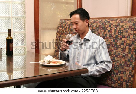business man having a sip of wine after finished up with his lunch