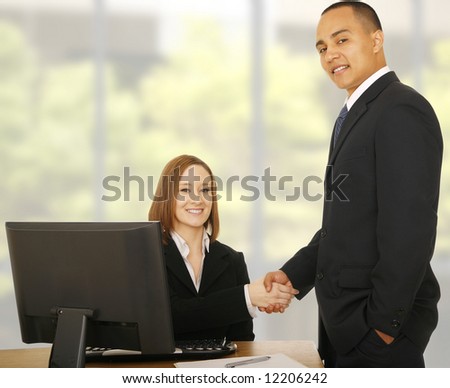 two business people shaking hand and looking at camera, both showing happy expression. great concept for business deal and business team