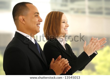 two business people clapping hand in office environment as if they are responding to presentation