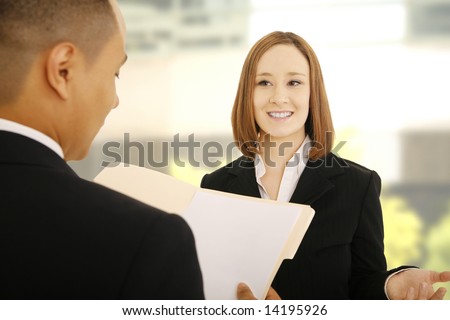 two business people talking about project. the man holding folder and the woman is talking about the project